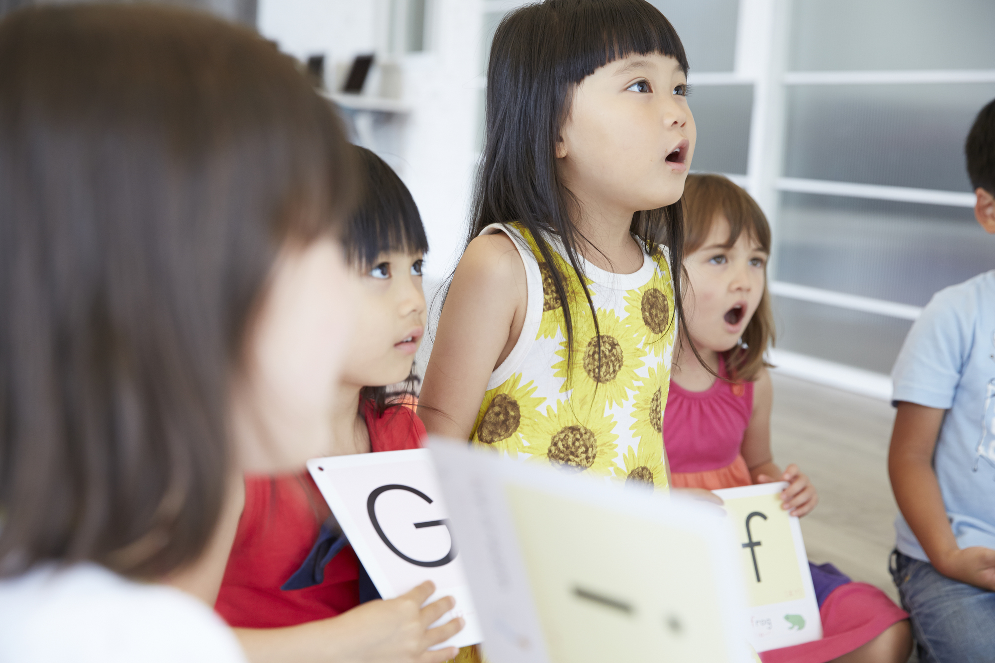 日本語と英語を使い分けるバイリンガル講師のレッスンを受ける子ども